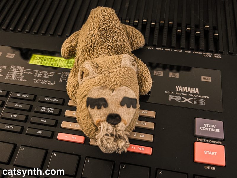 Closeup photo of a stuffed groundhog sitting atop a Yamaha RX5 drum machine.