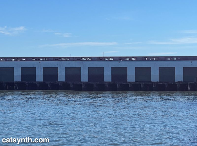 Side of a pier, with water below and sky above