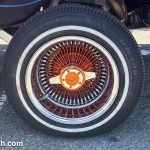 An elaborate wheel with a small tire on a lowrider car.