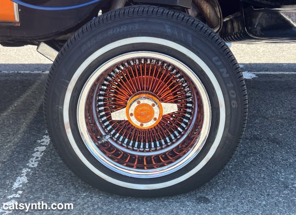 An elaborate wheel with a small tire on a lowrider car.