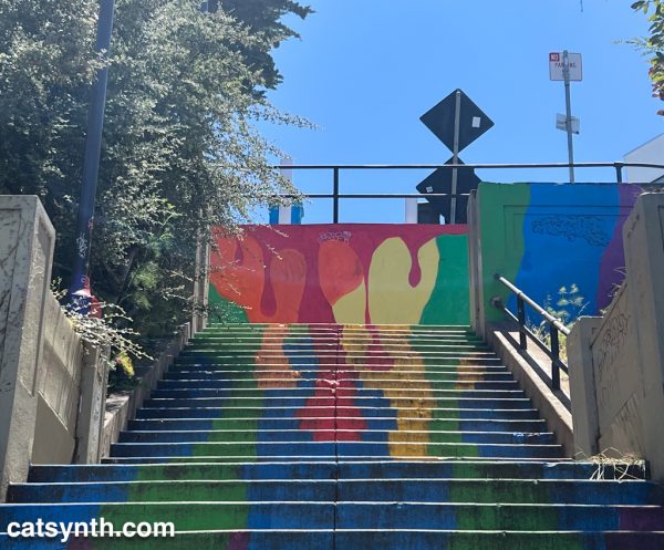Colorful abstract mural painted on an outdoor staircase connecting parts of a city street